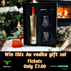 Au Vodka gift set giveaway displayed in front of a decorated Christmas tree and cosy fireplace. The gift set includes a golden bottle of Au Vodka, two branded glasses, and a pourer. A festive cranberry cocktail is placed beside it. Text on the image reads "Win this Au vodka gift set, Tickets only £1.00." Rendalls Competitions logo and Trustpilot 5-star rating are shown at the bottom of the image.